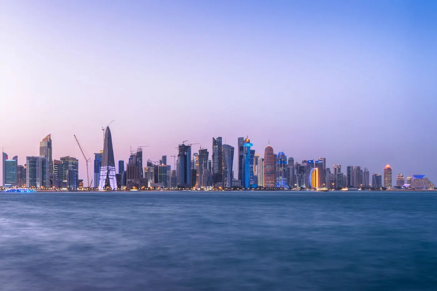 The Doha skyline at dusk across the bay