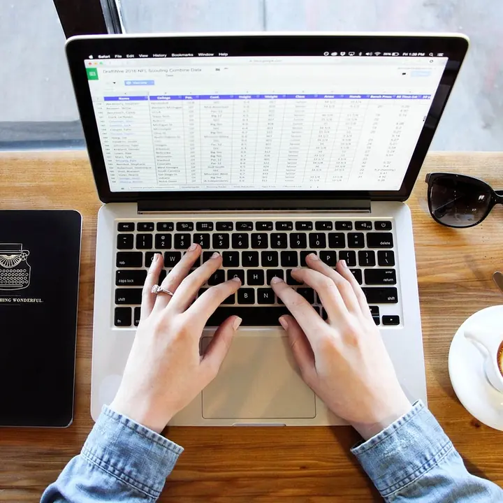 A laptop with a spreadsheet open on a desk