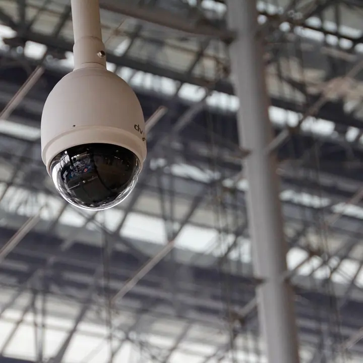 A dome security camera under a building roof